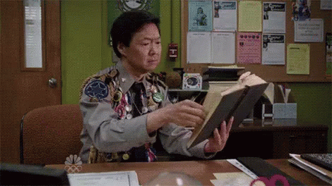 man flipping through book and stopping and smiling gif