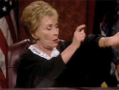 Judge Judy pointing at wrist watch and hitting table gif