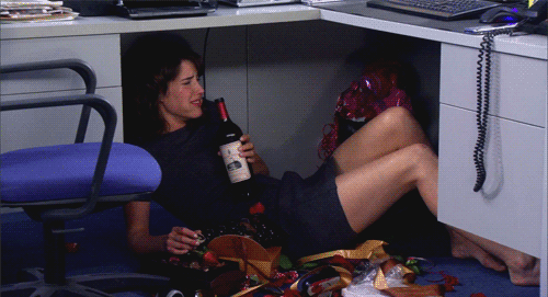 Robin in How I Met Your Mother crying and drinking under desk gif